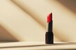 A red lipstick is sitting on a table in the sun
