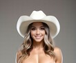 Portrait of a beautiful young woman in a white cowboy hat on a gray background