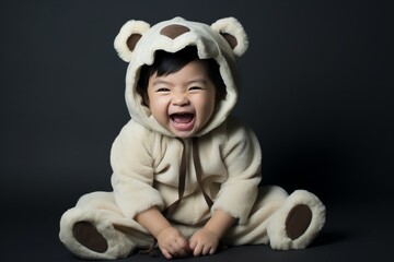 Wall Mural - A baby in a bear costume is smiling and laughing