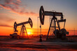 Oil pumps. Oil industry equipment. Work of oil pump jack on a oil field at sunset or sunrise.