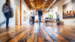People walking on a wooden floor in an office, captured in a wide shot with natural light and a low angle view, creating a blurred motion effect.