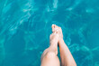 Slender female legs tasting the water. Concept of summer rest and vacation. Background with copy space.