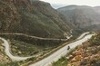 High angle shot of a person riding a bike on a highway in mountains