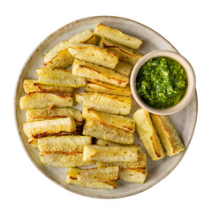 Wall Mural - Oven baked zucchini wedges served with green pesto. Vegetable chips on plate isolated on white  background.