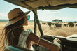 Woman tourist in vehicle in the savanna with wild elephants