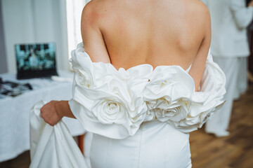 Woman in white wedding dress with ruffled sleeves, elegant gesture