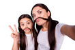 © deagreez - Close up photo beautiful two people brown haired mom small little daughter make take selfies moustache curls pretend guy man male show v-sign wear white t-shirts isolated bright blue background