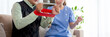 Asian caregiver woman or nurse training senior man stretch arm for exercise while therapy and rehabilitation in living room at home, caretaker or physiotherapist helping elderly workout with hands.