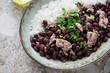 Closeup of black beans with rice and chicken meat served in a grey bowl, selective focus, horizontal shot