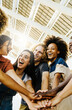 © Xavier Lorenzo - Vertical photo of multiracial happy friends with hands in stack. Multi-ethnic diverse group of college students joining their hands. Stacking hand concept, community, unity and teamwork concept