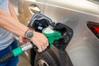 Close up view of driver hand fills up expensive gasoline in self-service filling station in Europe