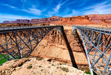 Fototapeta Las - Twin spandrel arch bridges over Marble Canyon washed out by Colorado river called new and historic “Navajo Bridge“. Tall majestic steel constructions from 1929 and 1995 built next to each other.