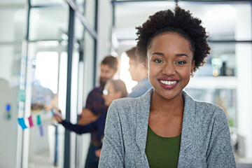 Canvas Print - Portrait, business and happy black woman in office, company and employee coworking in creative startup workplace. Face, professional and smile of female person, entrepreneur and career of editor