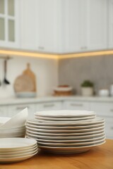 Poster - Clean plates and bowls on wooden table in kitchen