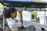 Fototapeta Natura - Happy black tourist woman sitting in local tuktuk exploring Thailand during summer vacation