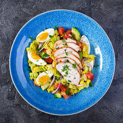 Wall Mural - Healthy chicken salad. Fresh salad with avocado, tomato, chicken and herbs. Top view