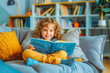 © VisualProduction - Happy kid sits on couch at home and reads book with enjoy and interest. Back to school, education, learning, reading, lifestyle concept