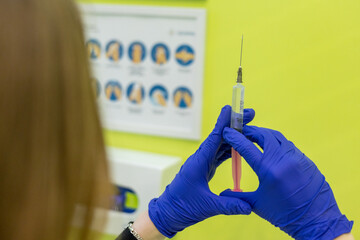 A nurse in blue gloves draws medicine into a syringe for an injection. Treatment in hospital. The doctor prepares a syringe for an injection. Therapeutic injections.