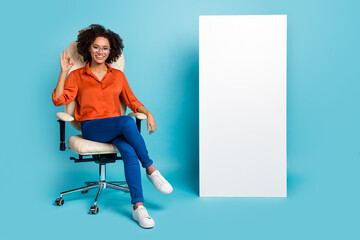 Poster - Photo of shiny lady worker dressed orange shirt glasses okey sign gadget empty space isolated blue color background