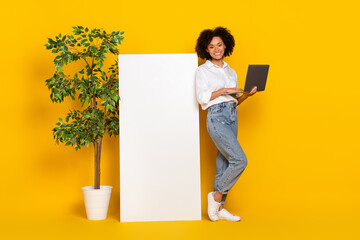 Poster - Full length body size view of attractive cheery girl assistant using laptop copy space ad isolated over bright yellow color background