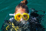Fototapeta  - A beautiful red hair latina scuba diver on sea surface after diving underwater