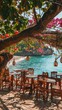 Authentic atmospheric cafe on Mexican bay beach under green trees overlooking clear blue water, colorful flowers