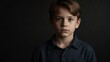 © Arceli - handsome kid boy looking at camera serious on dark plain black background from Generative AI