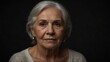 © Arceli - beautiful elder woman looking at camera serious on dark plain black background from Generative AI