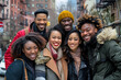 A group of multiethnic friends posing for the camera, smiling and laughing together in an urban setting