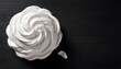 Sweet white meringue on a black wooden background