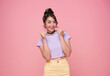 Portrait happy smile Asian teen woman showing thumb up isolated on pink background.