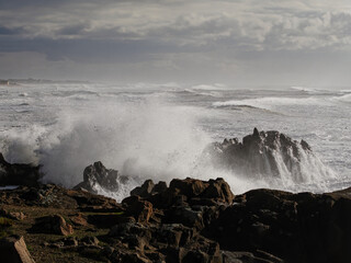 Canvas Print - Small cape being hit by strong stormy sea waves