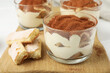 © New Africa - Delicious tiramisu in glasses and cookies on table, closeup