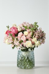 Poster - Beautiful bouquet of fresh flowers in vase on table near white wall