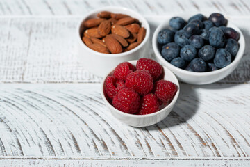 Wall Mural - fresh berries and nuts on white table