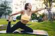 © Strelciuc - Full length view of a millennial woman practicing yoga outdoor in the morning during wellness retreat. Healthy lifestyle concept