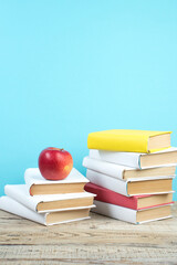 Wall Mural - Books stacking. Books on wooden table and blue background. Back to school. Copy space for ad text.