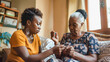 © Sabrina - Adult african daughter doing diabetes blood sugar test from senior mothers finger at home - Models by AI generative