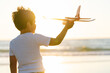 © Koldo_Studio - Boy with a toy plane in the glow of the sunset