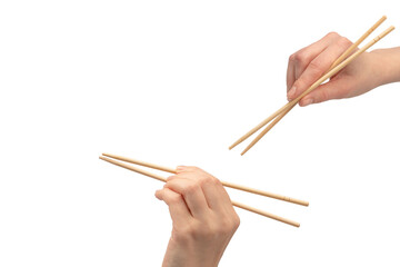 Wall Mural - Female hand holding wooden sushi chopsticks isolated on white background.