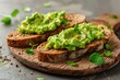Toast bread with avocado puree on wooden table. Vegetarian food.