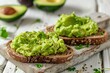 Toast breads with avocado puree on wooden table. Vegetarian food.