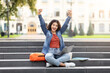 © Prostock-studio - Excited student with laptop on campus steps