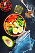 Delicious healthy brunch - boiled egg, smoked salmon, green salad and savory pancakes on a dark background, top view
