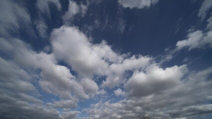 Wall Mural - time lapse fast moving white clouds and blue sky.