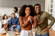 © Prostock-studio - Friends laughing and singing together sharing a mic