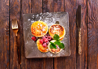 Canvas Print - Cottage cheese pancakes with raspberries on wooden background, breakfast or lunch