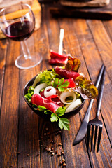 Poster - salad with jamon and red wine on wooden table