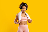 Fototapeta  - Cheerful african american lady with headphones and towel