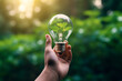 © ADDICTIVE STOCK CORE - Generative AI illustration of anonymous hand holds a clear light bulb with a small green plant inside symbolizing innovative green energy solutions